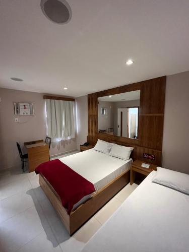 um quarto com 2 camas e uma secretária em Verona Hotel no Rio de Janeiro