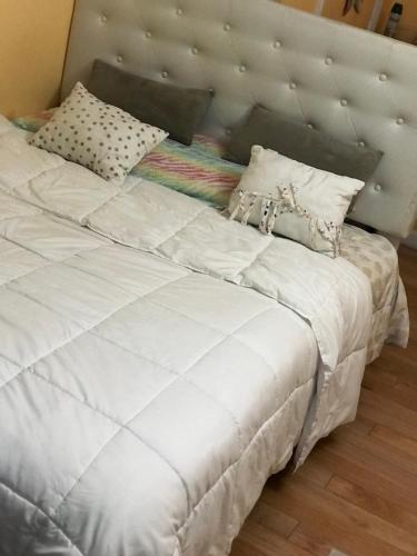 een bed met witte lakens en kussens erop bij Dream Room in Malba