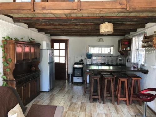 una cocina con techos de madera y una cocina con taburetes. en Casa en Cuchilla Alta, en Cuchilla Alta