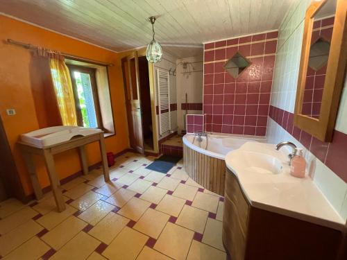 y baño con bañera, lavamanos y bañera. en Espace Famille Montmillon, en Chamblay