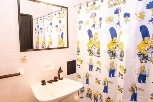 サンタ・テレシータにあるLa casita de la Costaの洗面台とシャワーカーテン付きのバスルーム