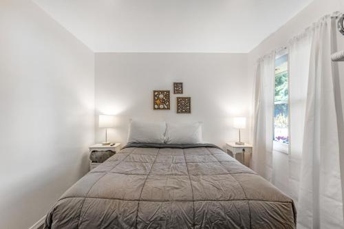 a white bedroom with a large bed and two lamps at Cute as a Clam Cottage Room 2 in Ocean Park