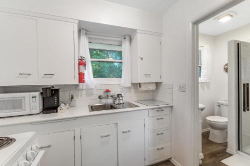 cocina blanca con fregadero y microondas en Cute as a Clam Cottage Room 2, en Ocean Park