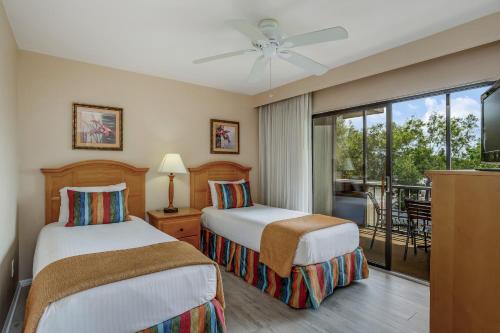 two beds in a hotel room with a balcony at Fabulous Park Shore Condo in Naples