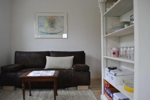 sala de estar con sofá de cuero y mesa en Ferienwohnung Himmel, en Oberstaufen