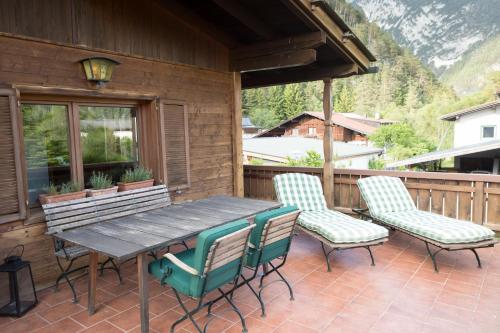 einen Holztisch und Stühle auf einer Terrasse in der Unterkunft Scharnitz Chalet - gut eingerichtetes Haus in Scharnitz