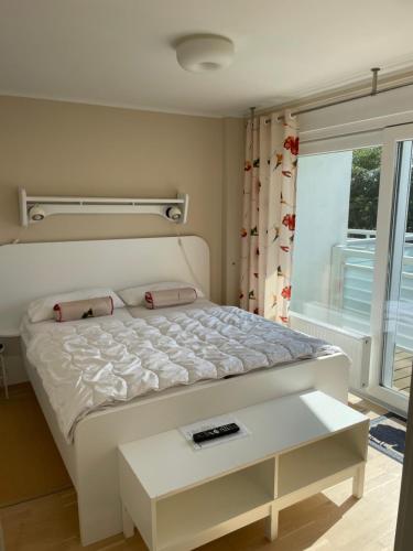 a bedroom with a white bed and a window at Apartment Strandglück in Dierhagen