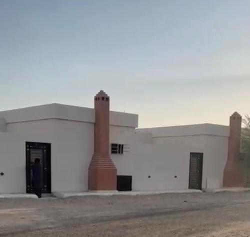 a white building with two chimneys on the side of it at تذكار in Qal'at Bishah