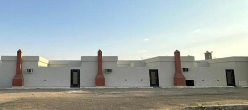 a large white building with four chimneys on it at تذكار in Qal'at Bishah