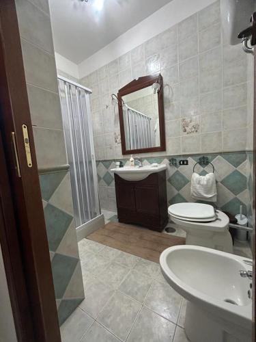 a bathroom with a sink and a toilet and a mirror at CASA VACANZA BELVEDERE in Ercolano