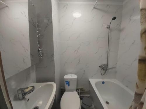 a bathroom with a toilet and a sink and a tub at Отличная квартира со всеми удобствами. in Almaty