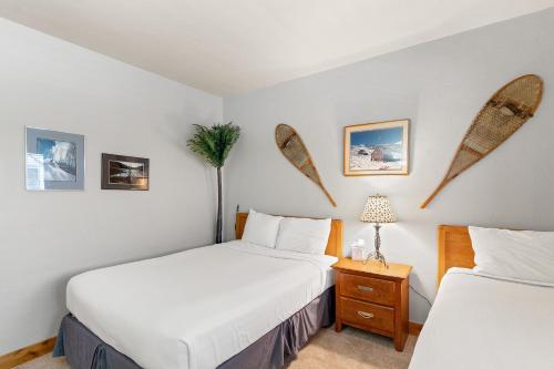 two beds in a room with surfboards on the wall at Snow Flower 206 in Steamboat Springs