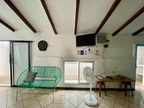 a living room with a green chair and a table at Hostal Inn 2 in Flores