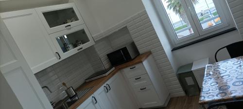 a kitchen with white cabinets and a sink at A un passo dal mare CIN ITO1OO59C29ZGY7FLN in Riva Trigoso