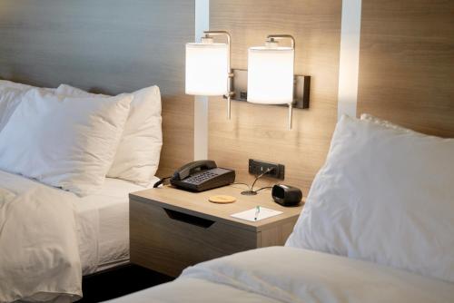 a hotel room with a phone on a table between two beds at Brady Hotel in New Florence