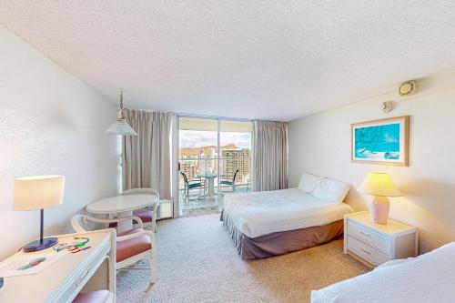 ein Hotelzimmer mit einem Bett, einem Schreibtisch und einem Tisch in der Unterkunft Island Colony 3519 - 30 night minimum in Honolulu