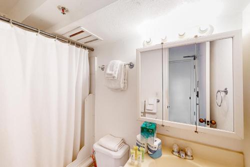 a bathroom with a sink and a toilet and a mirror at Island Colony 3519 - 30 night minimum in Honolulu