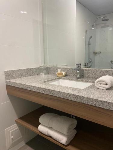 a bathroom with a sink and a mirror and towels at Del Prado Hotel in Lima