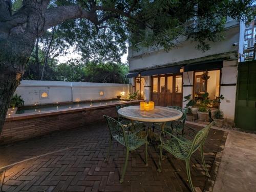 een patio met een tafel en stoelen en een gebouw bij Thanga House by LuxUnlock Private Villas in Tarangambādi