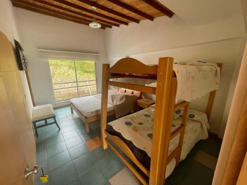 a bedroom with two bunk beds in a room at Hotel Familiar El Remanso Del Agua in Guatapé