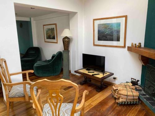 a living room with a fireplace and a green chair at Garzonier Estilo Cabaña in La Paz