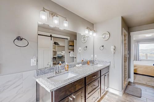 uma casa de banho com um lavatório e um espelho grande em Serenity em Garden City