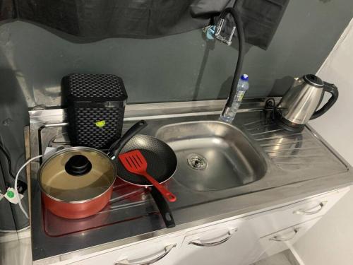 a kitchen counter with a sink with pots and pans at Apartamento Passo Fundo in Passo Fundo