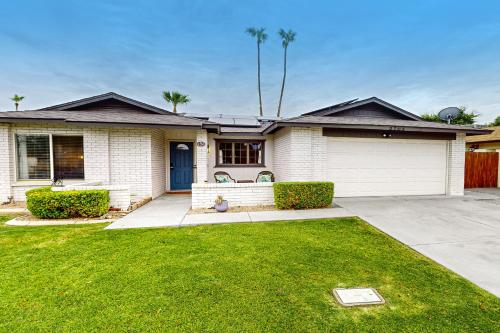a white house with a blue door and a yard at Palm Reflection in Mesa