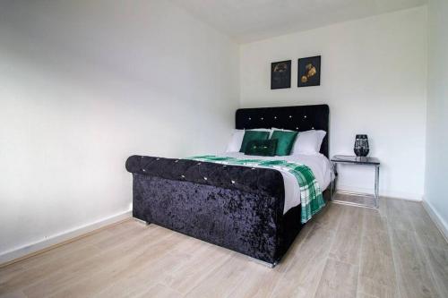 a bedroom with a large bed with green pillows at Shazeal Apartments in Birmingham