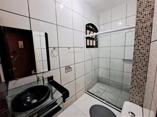 ein Bad mit einem schwarzen Waschbecken und einer Dusche in der Unterkunft Descanso a beira mar casa completa em Mambucaba in Tarituba