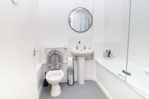a bathroom with a toilet and a sink and a mirror at Shazeal Apartments in Birmingham