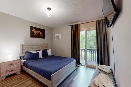 - une chambre avec un lit et une grande fenêtre dans l'établissement Brentwood Burrow, à East Stroudsburg