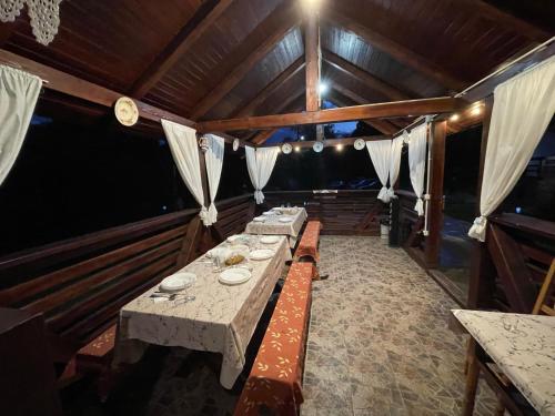 a dining room with a long table in a house at Pensiunea Nituca in Moisei