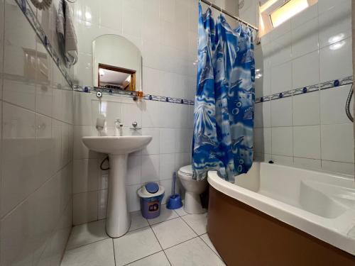 ein Badezimmer mit einem Waschbecken, einer Badewanne und einem WC in der Unterkunft MASSAGET HOTEL in Nukus