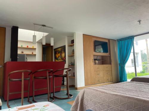 a bedroom with a bed and two bar stools at Hotel Familiar El Remanso Del Agua in Guatapé