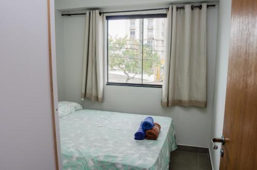 a small bedroom with a bed and a window at Apto 2 qts, wifi, netflix, metrô próximo in Brasília