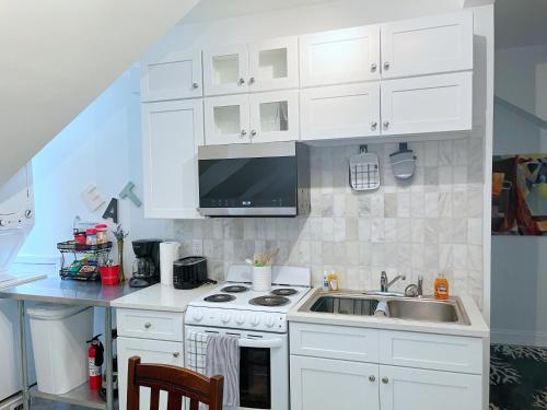 a white kitchen with a sink and a stove at Elegant Guest Studio in Upscale Community in Covington