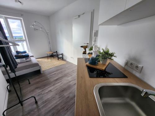 a kitchen with a sink and a living room at Cozy Apartment with WIFI, Near University&Hospital in Augsburg