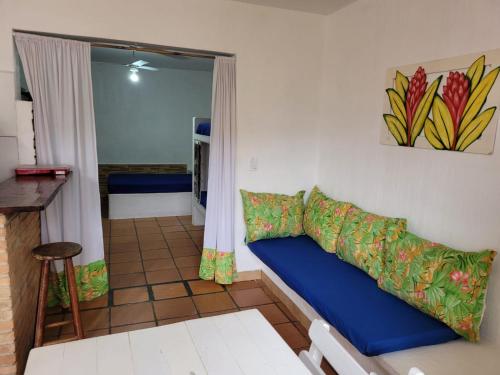a living room with a blue couch in a room at Kitchenette Charmosa no Itagua in Ubatuba