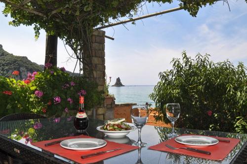 a table with a plate of food and wine glasses at Dandidis Seaside Pension in Agios Gordios