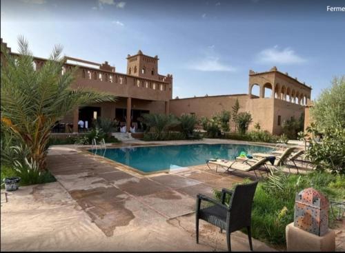 a large building with a swimming pool in a yard at Auberge Famille Benmoro in Skoura