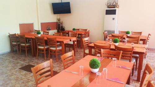 une salle à manger avec tables et chaises et une télévision dans l'établissement Family Hotel Avenue , à Kiten