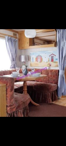 a living room with a table and a couch at Mackies Memories. in Hemsby