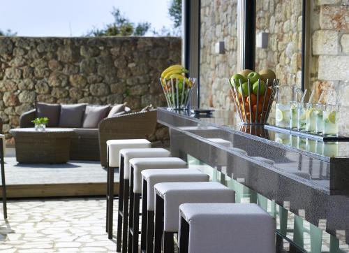 a bar with a row of chairs and a table at Anaxo Resort in Riglia