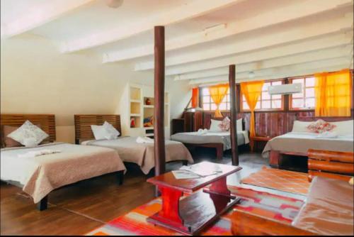 a hotel room with two beds and a table at Hotel La Colina in Manuel Antonio