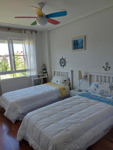 a bedroom with two beds and a ceiling fan at Chalet urbano en Salamanca in Santa Marta de Tormes