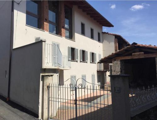 une maison blanche avec une clôture devant elle dans l'établissement Horse Shoe House, à Chiaverano