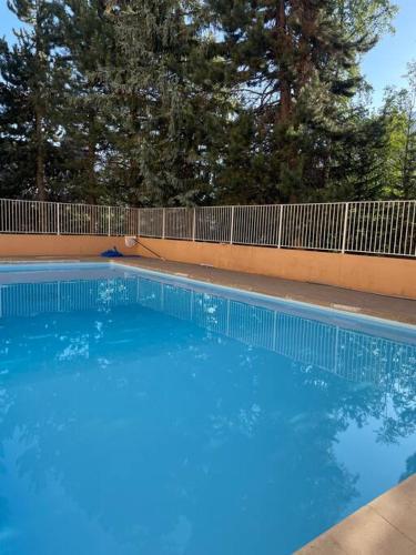 une grande piscine bleue à côté d'une clôture dans l'établissement Appartement deux alpes pied des pistes, à Les Deux Alpes
