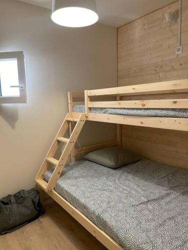 Ce lit superposé se trouve dans un dortoir doté d'un mur. dans l'établissement Appartement deux alpes pied des pistes, à Les Deux Alpes