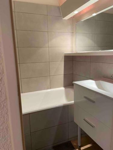 une salle de bain avec une baignoire et un lavabo dans l'établissement Appartement deux alpes pied des pistes, à Les Deux Alpes